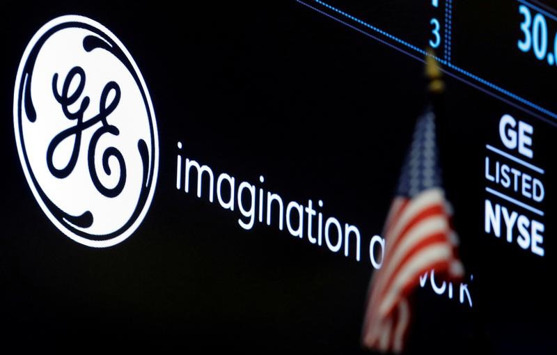 FILE PHOTO: The ticker and logo for General Electric Co. is displayed on a screen at the post where it's traded on the floor of the NYSE