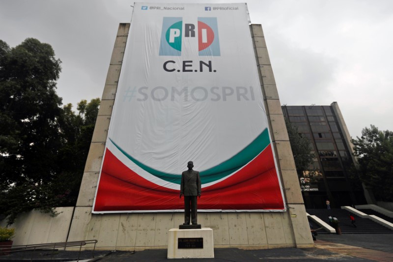 A banner of the Institutional Revolutionary Party is pictured behind a statue of the General Lazaro Cardenas del Rio at PRI headquarters in Mexico City