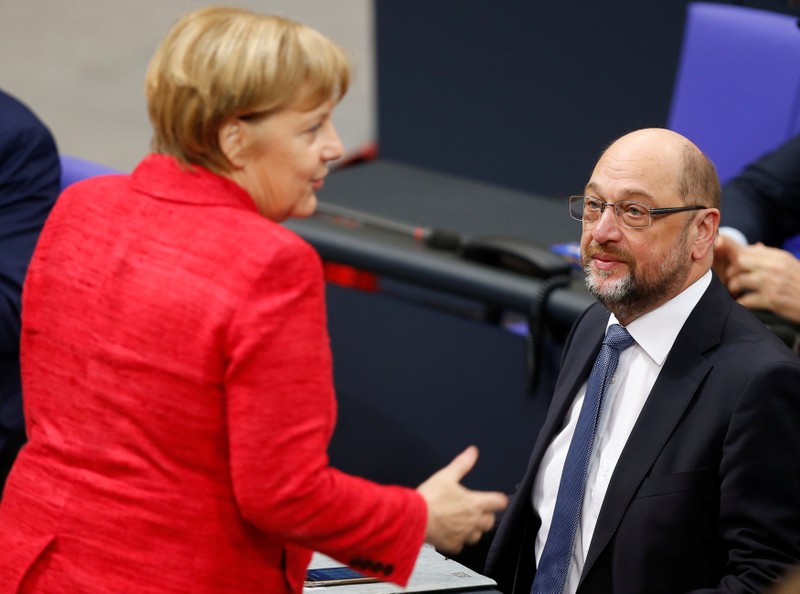 German Chancellor Angela Merkel speaks with Social Democratic Party (SPD) leader Martin Schulz as they attend a meeting of the Bundestag in Berlin