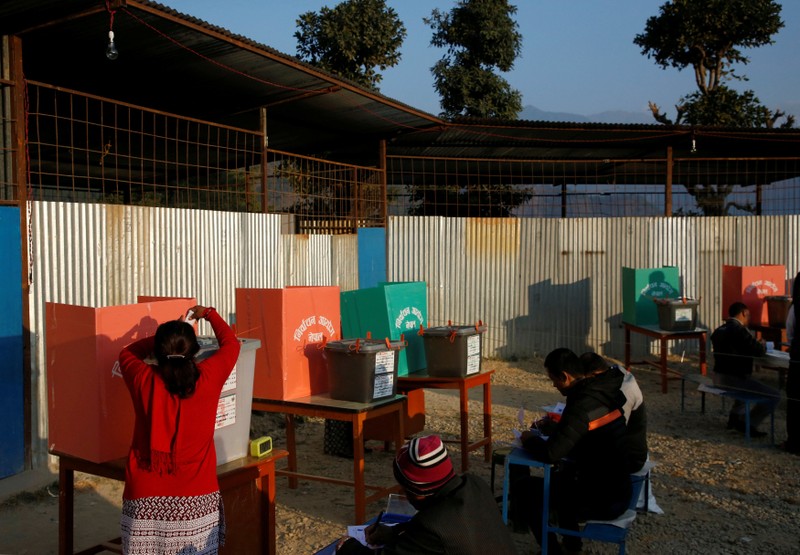 A woman casts her vote in a ballot box during the parliamentary and provincial elections at Chautara in Sindhupalchok District