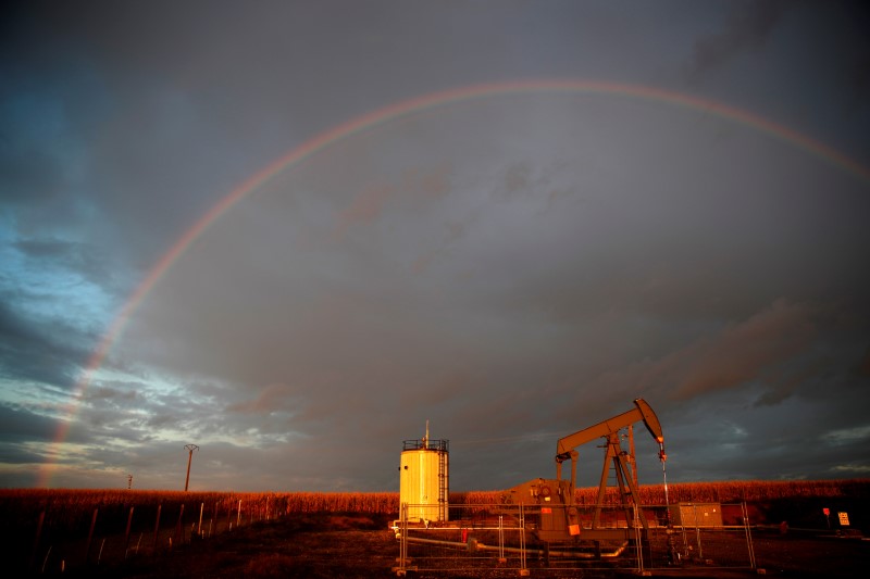 A rainbow is seen over a pumpjack during sunset outside Scheibenhard