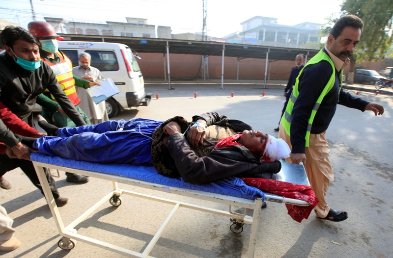 Rescue personnel transport a man injured during clashes between police and protesters, at a hospital for treatment in Rawalpindi, Pakistan