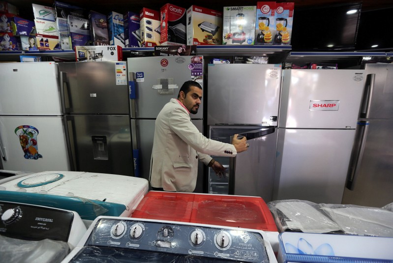 A Palestinian man checks a refrigerator in an electrical appliances store in Khan Younis in the southern Gaza Strip