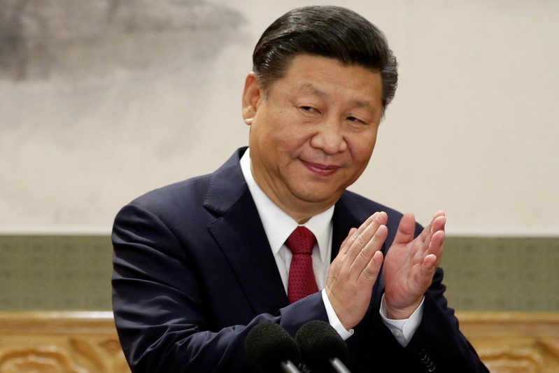 China's President Xi Jinping claps after his speech as he and other new Politburo Standing Committee members meet with the press at the Great Hall of the People in Beijing