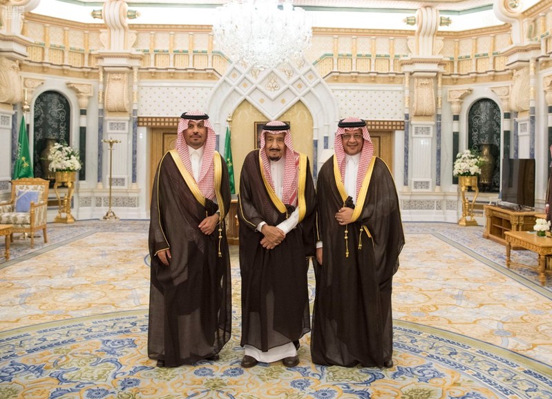 Saudi King Salman bin Abdulaziz Al Saud poses for a photo with National Guard Minister Khaled bin Ayyaf and Economy Minister Mohammed al-Tuwaijri during a swearing-in ceremony in Riyadh