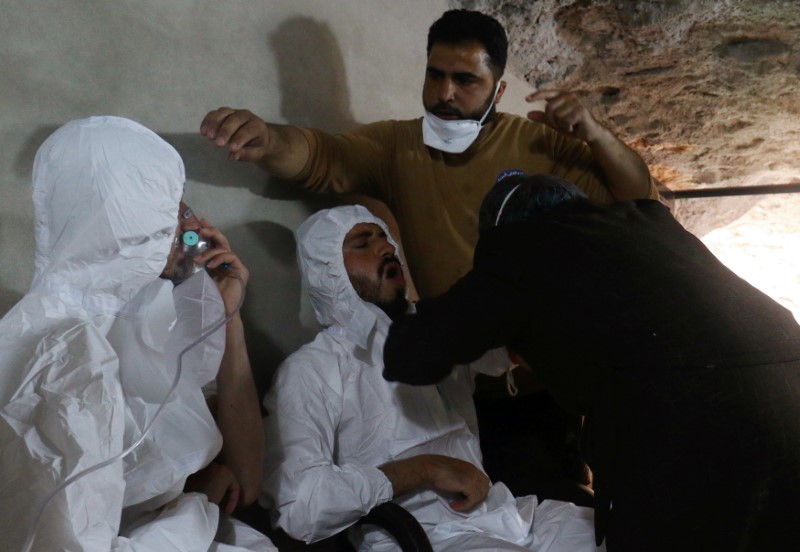 FILE PHOTO: A man breathes through an oxygen mask as another one receives treatments, after what rescue workers described as a suspected gas attack in the town of Khan Sheikhoun in rebel-held Idlib
