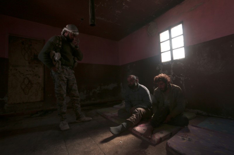 An Syrian Democratic Forces(SDF) fighter stands near what he said was Islamic State fighters held prisioners by them , north of Raqqa city