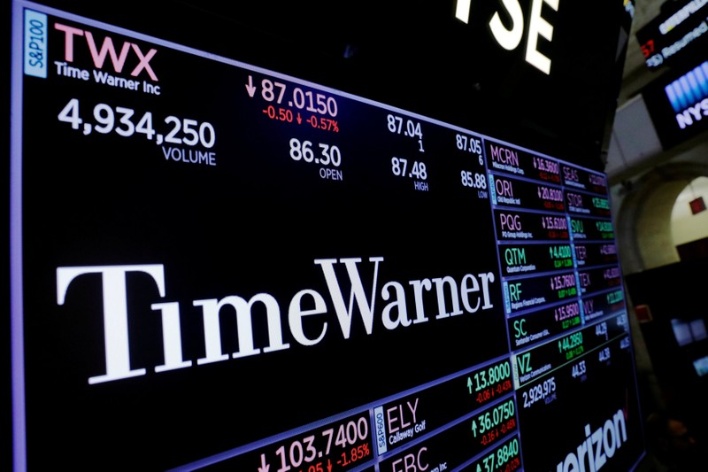 A screen shows the current price of Time Warner shares, above the floor of the New York Stock Exchange, shortly after the opening bell in New York