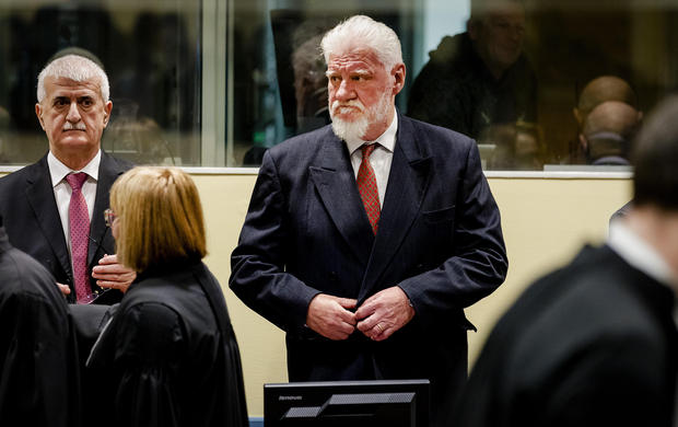 War crimes trial halted as convict drinks purported poison