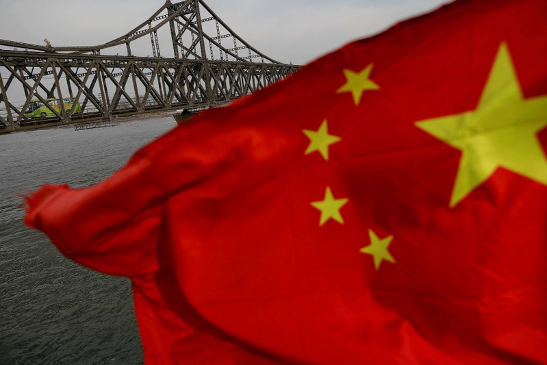 FILE PHOTO: A Chinese flag is seen in front of the Friendship bridge over the Yalu River connecting the North Korean town of Sinuiju and Dandong in China