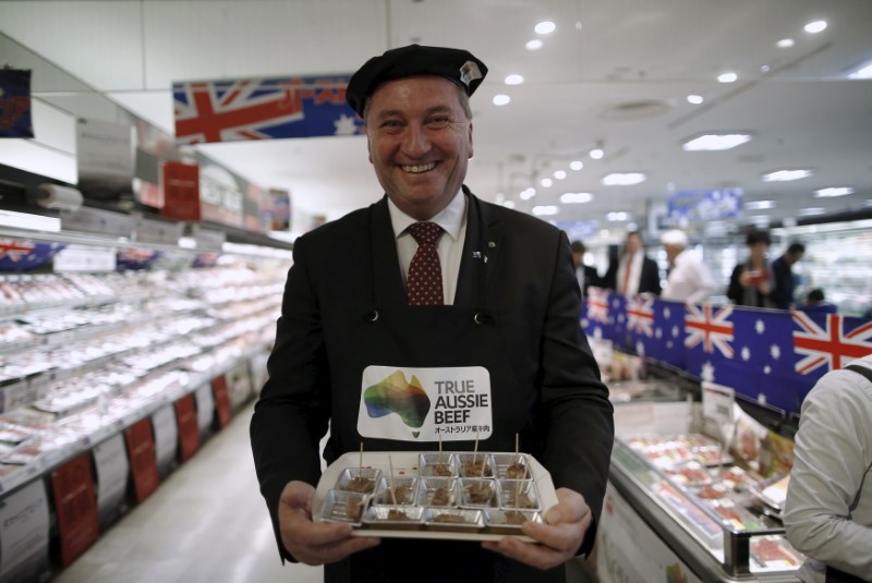 Australian Minister for Agriculture and Water Resources Barnaby Joyce smiles as he serves sampling Australian beef food to customers to promote Australian products at a supermarket in Tokyo