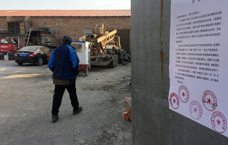 A removal notice from local government is seen posted on the gate of a yard where delivery workers stay in Shigezhuang village in Beijing