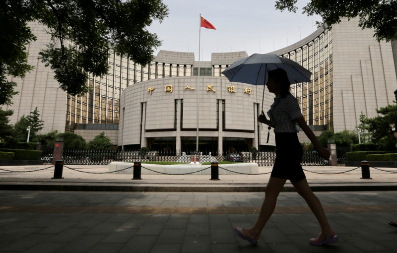 FILE PHOTO: Woman walks past the headquarters of the PBOC in Beijing