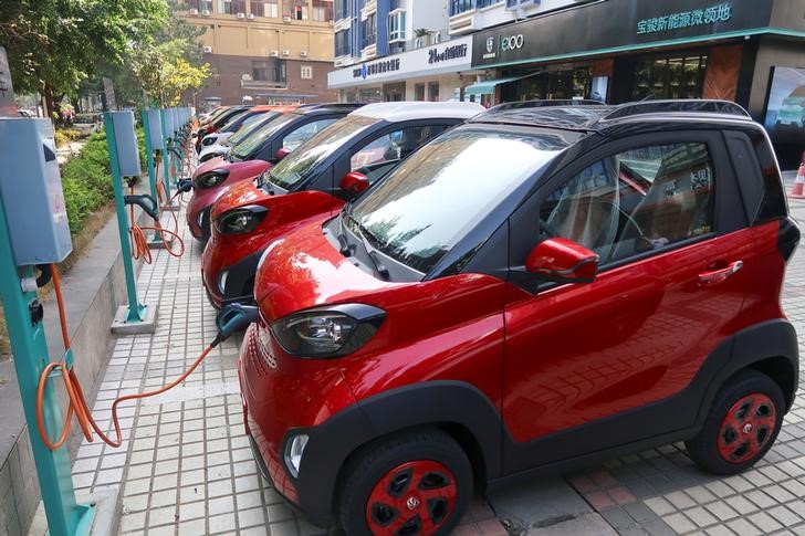 Baojun E100 all-electric battery cars are being charged in the parking lot in front of a Baojun NEV Experience Center store in Liuzhou