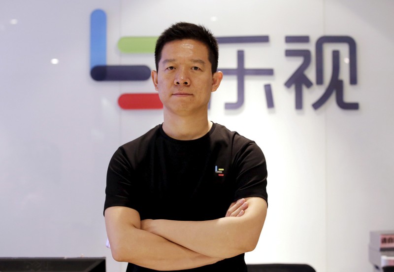 FILE PHOTO: Jia Yueting, co-founder and head of Le Holdings Co Ltd, poses for a photo in front of a logo of his company in Beijing