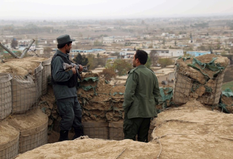 Afghan police officers keep watch at their forward base on the outskirts of Kunduz province