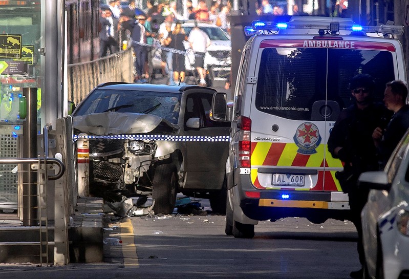 FILE PHOTO - Australian police stand near a crashed vehicle after they arrested the driver of a vehicle that had ploughed into pedestrians at a crowded intersection near the Flinders Street train station in central Melbourne