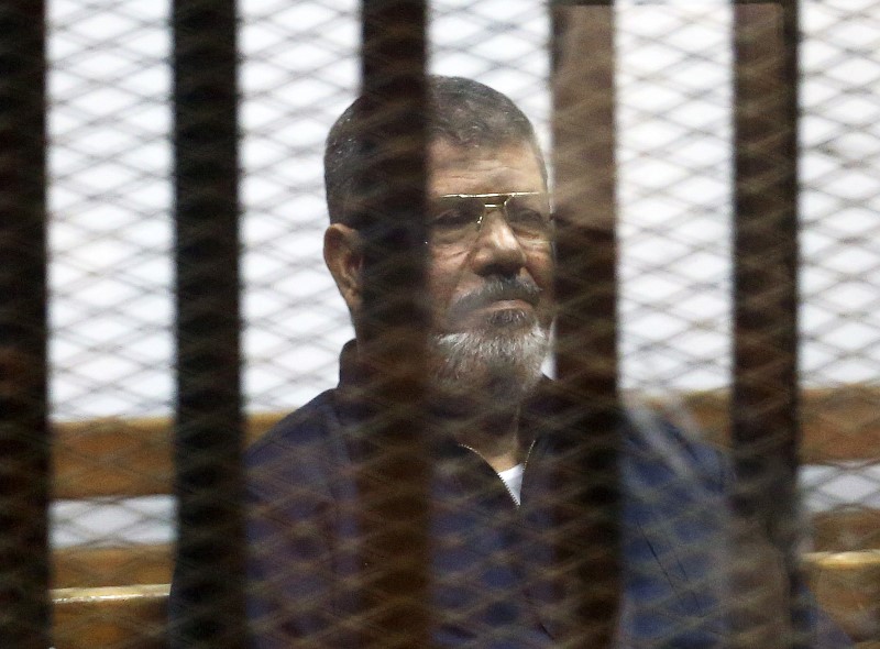 File photo of deposed Egyptian President Mursi listening to his verdict behind bars at a court on the outskirts of Cairo