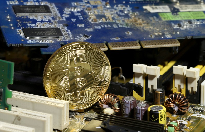 FILE PHOTO: A copy of bitcoin standing on PC motherboard is seen in this illustration picture