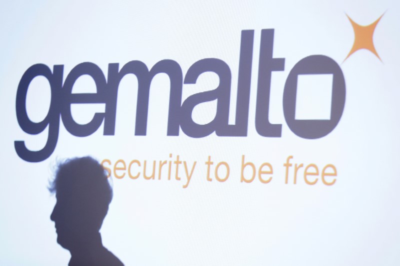 The shadow of an attendee is cast below a logo of Franco-Dutch technology firm Gemalto during a news conference in Paris