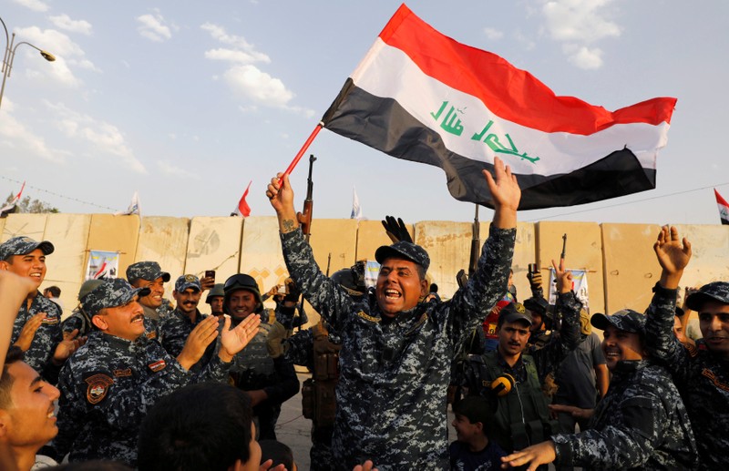 FILE PHOTO: A member of Iraqi Federal Police waves an Iraqi flag as they celebrate victory of military operations against the Islamic State militants in West Mosul