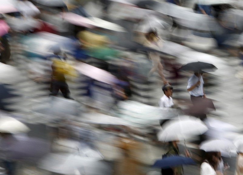 People holding their umbrellas cross a street in Tokyo