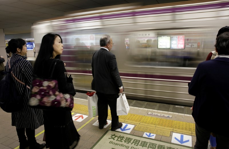 Commuters wait for a train in Osaka