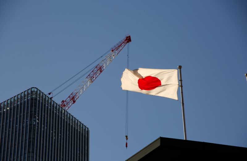 Japan's national flag is seen in front of a crane at a construction site at a business district in Tokyo