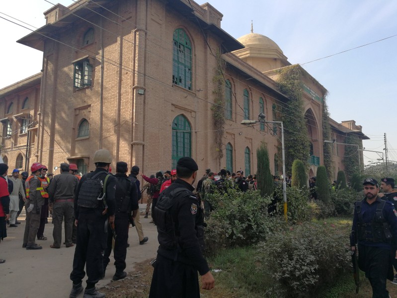 Police and rescue workers stand outside the Directorate of Agriculture Institute in Peshawar