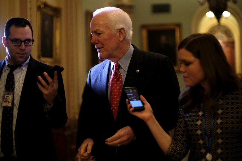 U.S. Senate Majority Whip Cornyn speaks to reporters on his way to the Senate floor during debate over the Republican tax reform plan in Washington