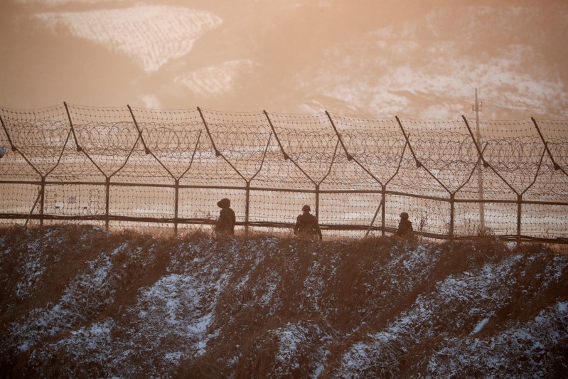 South Korean soldiers patrol along a barbed-wire fence near the militarized zone separating the two Koreas, in Paju