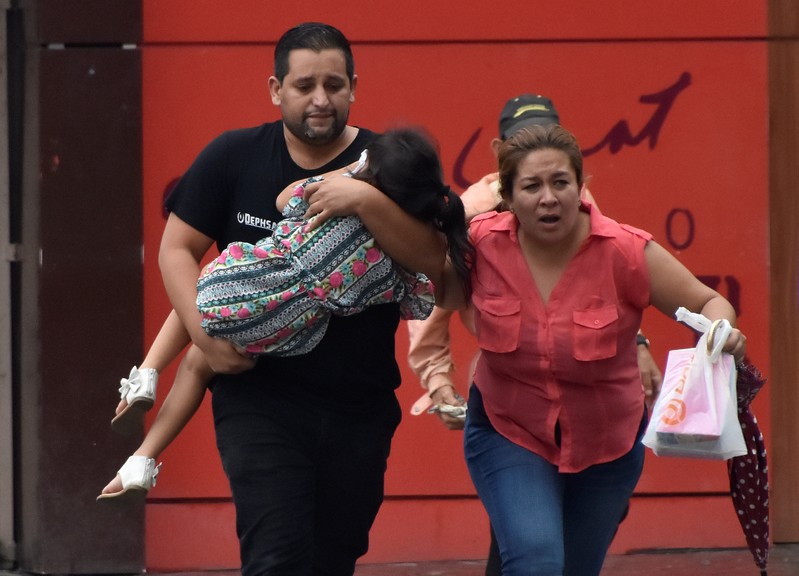 Family runs away from tear gas during clashes between supporters of Nasralla and police during a protest caused by the delayed vote count for the presidential election in San Pedro Sula