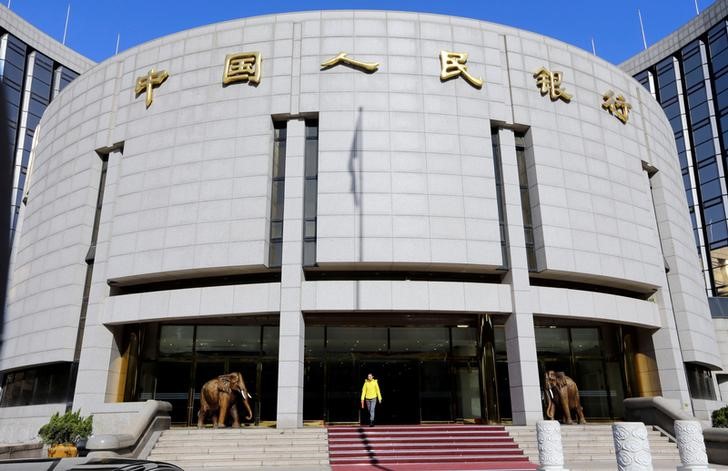 FILE PHOTO - A woman walks out of the headquarters of PBOC in Beijing