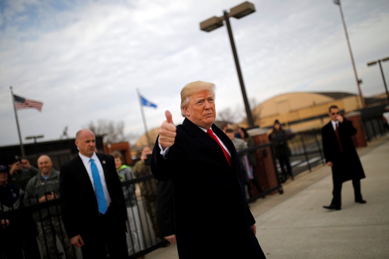 U.S. President Donald Trump gives a thumbs-up to reporters as he boards Air Force One for travel to Palm Beach from Joint Base Andrews