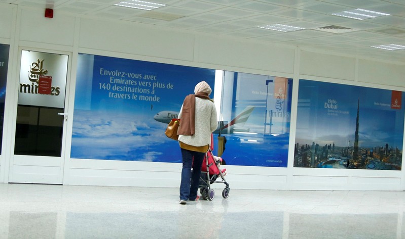 A women are seen in front of the Dubai airline Emirates office, at Tunis-Carthage International Airport in Tunis
