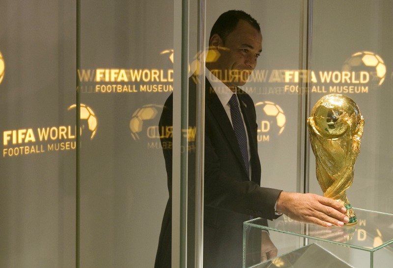 Brazil's former soccer player Cafu places the FIFA World Cup trophy into a glass cabinet during a media preview at the new FIFA World Football Museum in Zurich