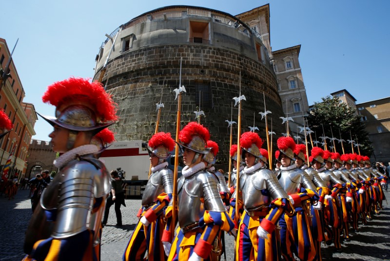 New recruits of the Vatican's elite Swiss Guard march in front of the tower of the Institute for Works of Religion during the swearing-in ceremony at the Vatican