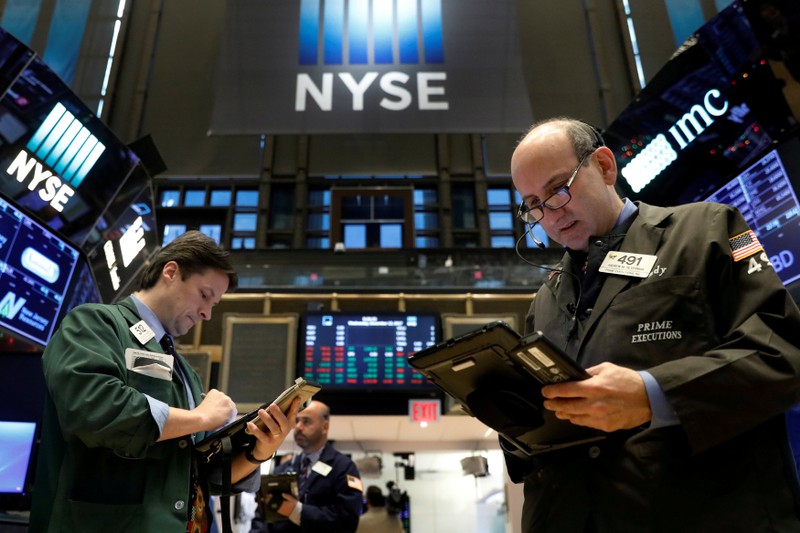 FILE PHOTO: Traders work on the floor of the NYSE in New York