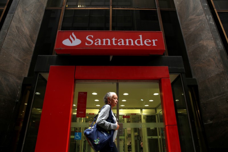 A woman walks past a Banco Santander branch in downtown