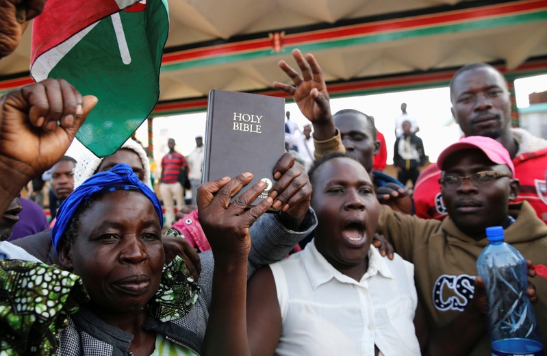 Supporters of Kenyan opposition leader Raila Odinga of the National Super Alliance (NASA) coalition hold a Bible ahead of his planned swearing-in ceremony as the president of the people’s assembly in Nairobi