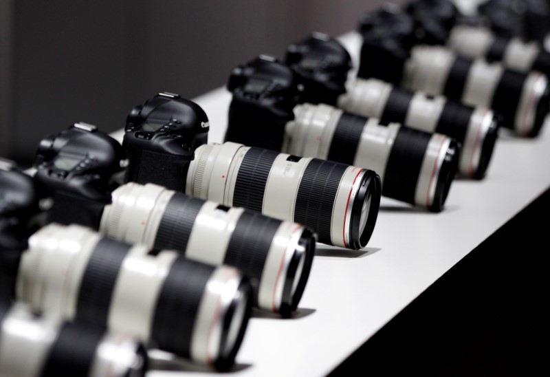 FILE PHOTO: Canon cameras with lenses are pictured at the stand of Japanese camera maker Canon on the press day of the world's largest fair for imaging in Cologne