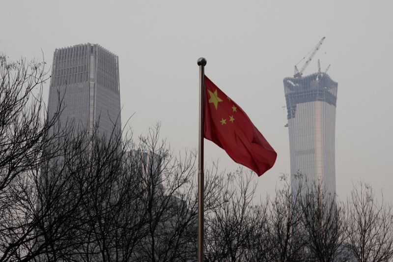 China World Trade Center Tower III and China Zun Tower under construction are pictured behind a Chinese flag in Beijing