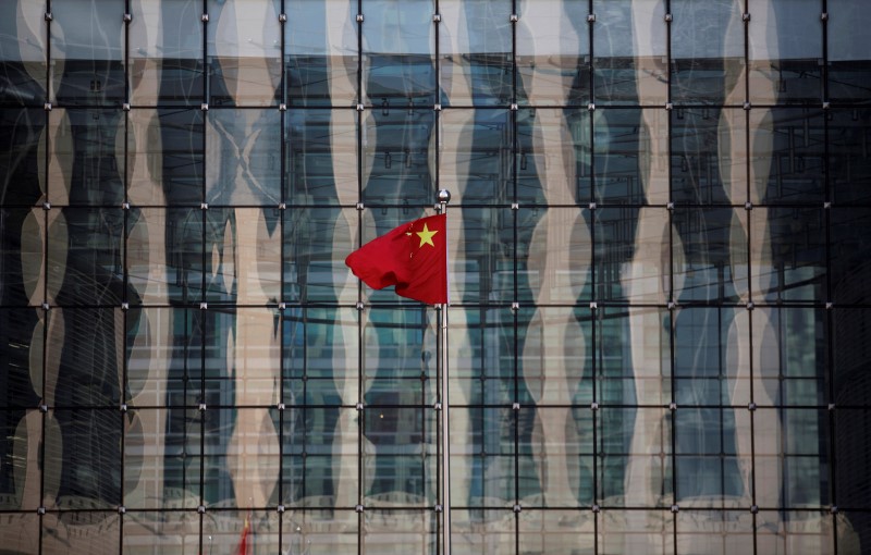 FILE PHOTO: A Chinese national flag flutters at the headquarters of a commercial bank on a financial street in central Beijing