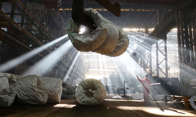 Worker directs a crane lifting steel wires at a factory of Dongbei Special Steel Group Co., Ltd. in Dalian