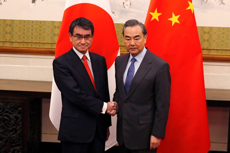 Japanese Foreign Minister Taro Kono and Chinese counterpart Wang Yi pose for photograph before their meeting in Beijing