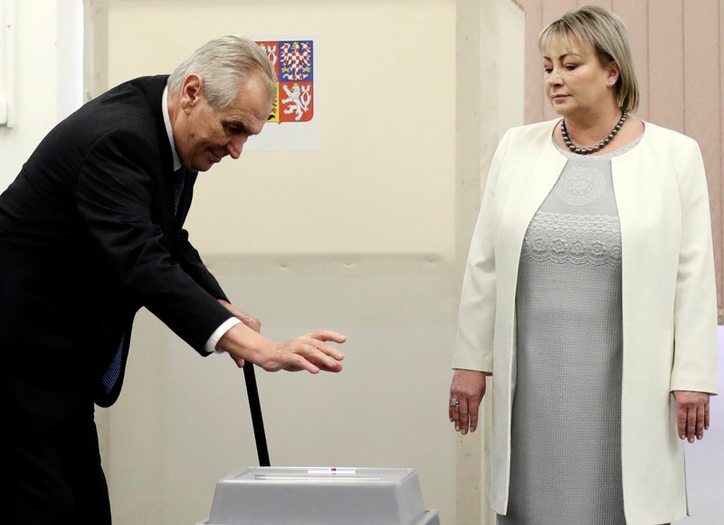 Incumbent president Milos Zeman casts his vote as his wife Ivana watches at a polling station during the second round of the presidential election in Prague