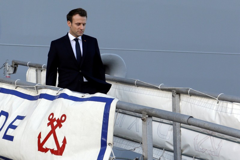 French President Emmanuel Macron heads down the gangway of the French war ship Dixmude docked in the French Navy base of Toulon