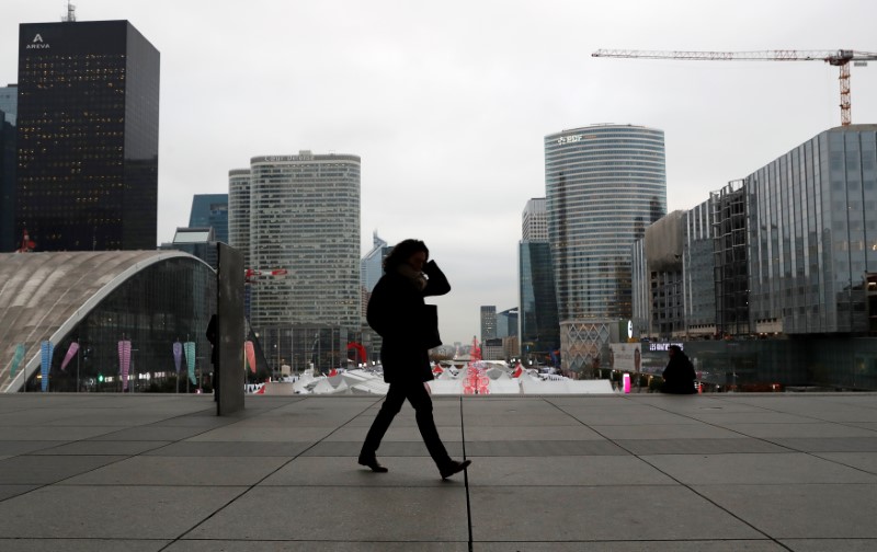 A woman walks on the esplanade of La Defense, in the financial and business district of La Defense, west of Paris