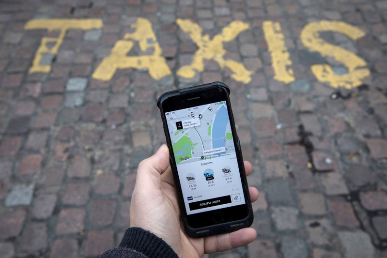 FILE PHOTO: A photo illustration shows the Uber app on a mobile telephone, as it is held up for a posed photograph, in London