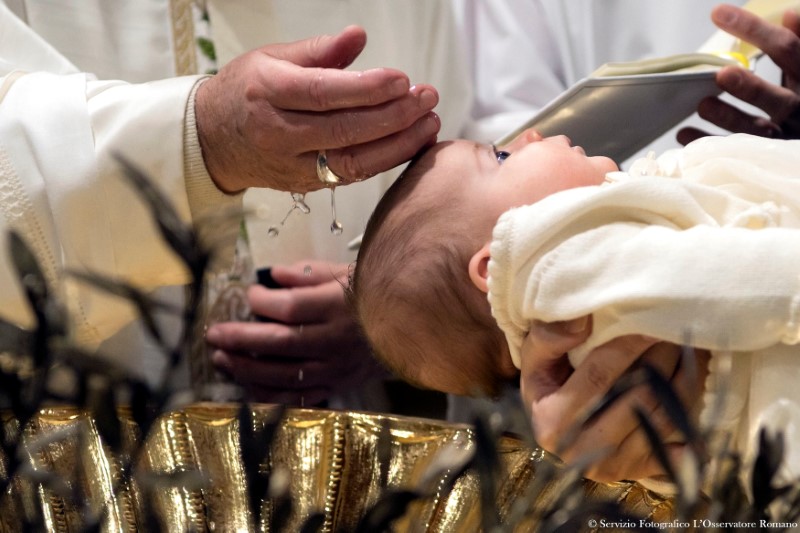 Pope Francis baptizes a baby during a ceremony in the Sistine Chapel at the Vatican